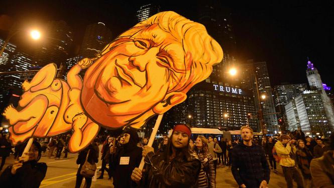 TOPSHOT - People take part in a protest near the Trump tower, against President-elect Donald Trump, in Chicago, Illinois on November 9, 2016. / AFP PHOTO / Paul Beaty